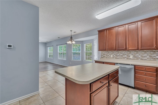 kitchen with pendant lighting, dishwasher, a center island, a notable chandelier, and backsplash