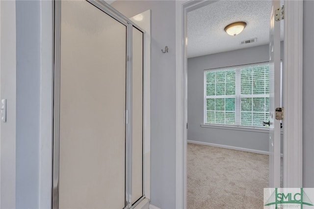 bathroom with a textured ceiling and walk in shower