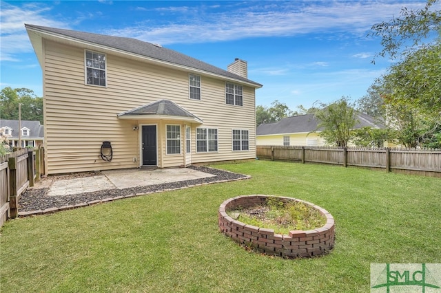 back of property with a lawn and a patio area