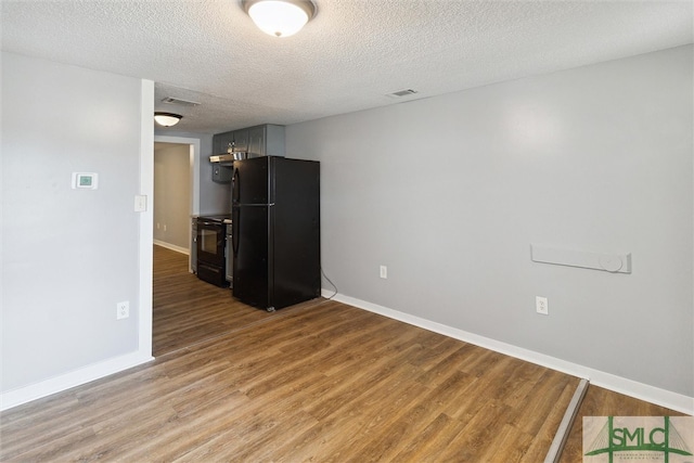 interior space with a textured ceiling and hardwood / wood-style flooring