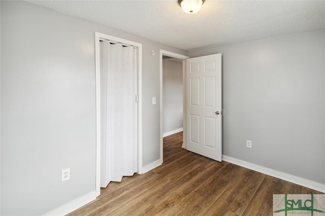 unfurnished bedroom featuring wood-type flooring, a textured ceiling, and a closet