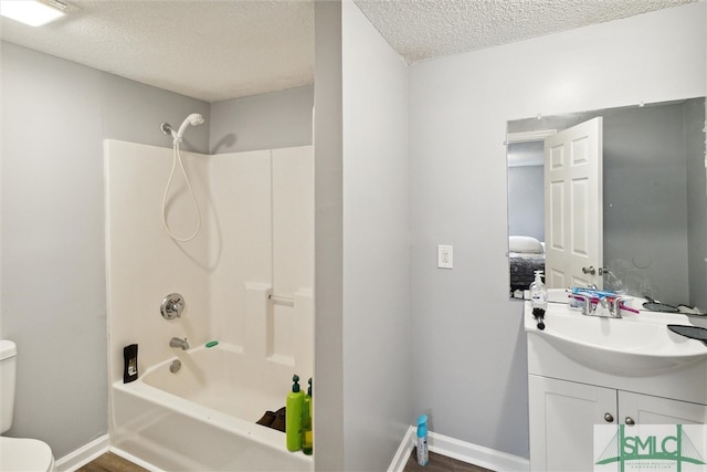 full bathroom with shower / bathing tub combination, a textured ceiling, vanity, and toilet