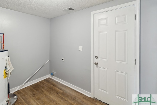 laundry room featuring a textured ceiling, water heater, dark hardwood / wood-style floors, and hookup for an electric dryer