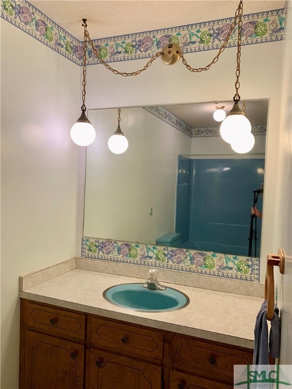 bathroom with a textured ceiling and vanity