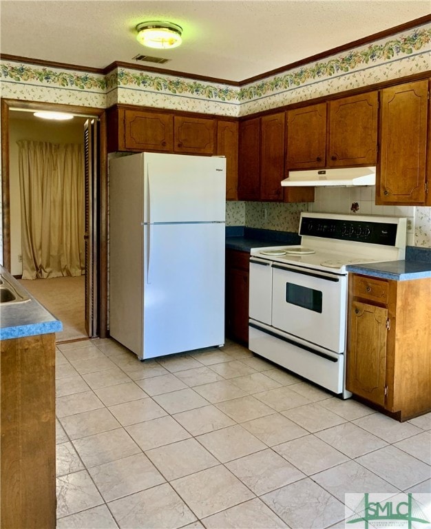 kitchen with ornamental molding, white appliances, and light tile patterned floors