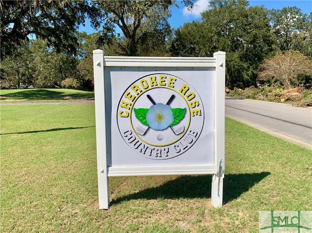 community sign featuring a yard