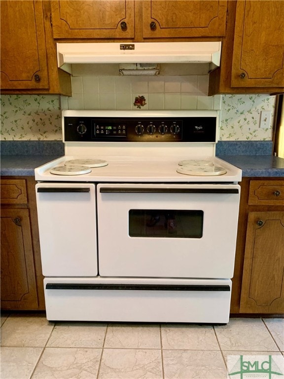 kitchen with electric stove, light tile patterned flooring, and tasteful backsplash