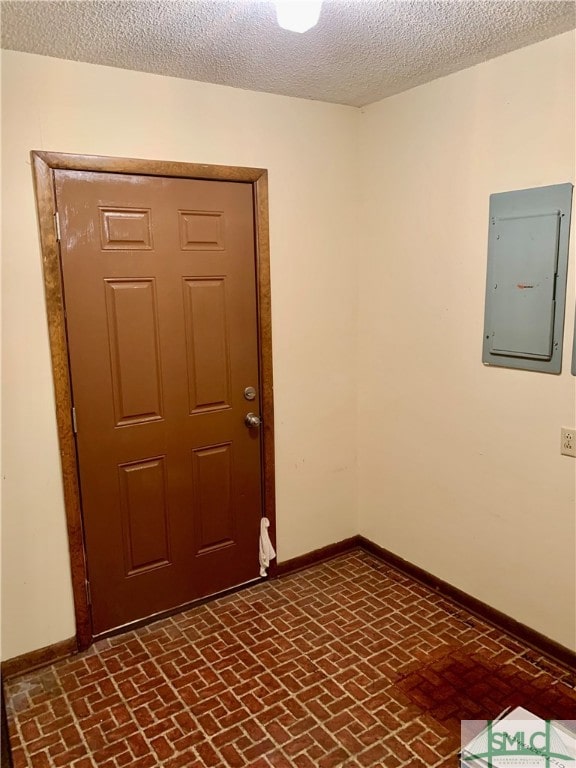 interior space with electric panel and a textured ceiling