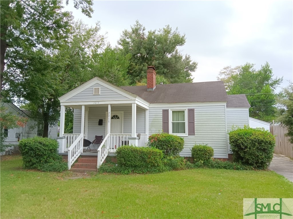 view of front facade featuring a front yard and covered porch