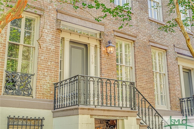 view of exterior entry featuring a balcony