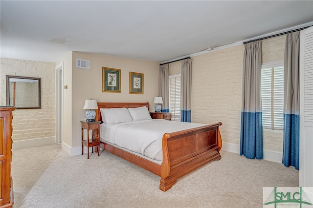 carpeted bedroom with brick wall