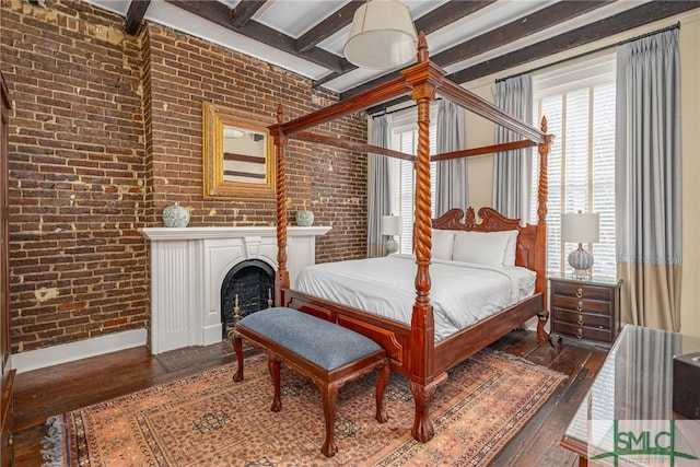 bedroom featuring brick wall, beamed ceiling, and dark hardwood / wood-style floors