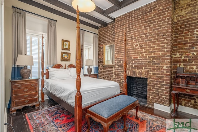 bedroom with a brick fireplace, dark hardwood / wood-style floors, beamed ceiling, and brick wall