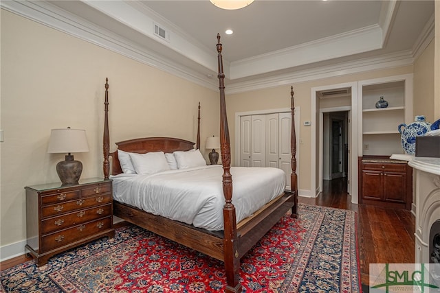 bedroom with crown molding, dark wood-type flooring, and a closet