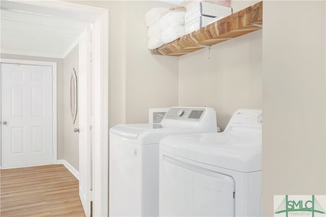 washroom with washer and dryer and light hardwood / wood-style floors