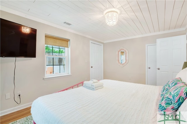 bedroom featuring wooden ceiling, light hardwood / wood-style flooring, and ornamental molding