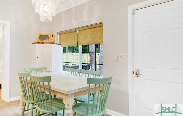 tiled dining room with a chandelier