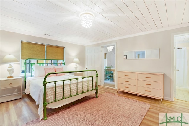 bedroom featuring light wood-type flooring, an inviting chandelier, ornamental molding, and wood ceiling