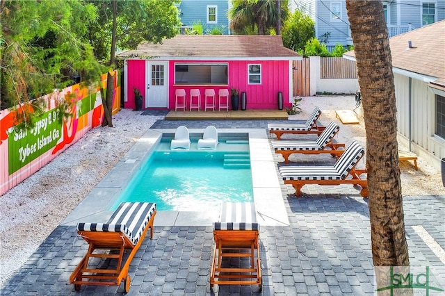 view of pool featuring an outbuilding and a patio