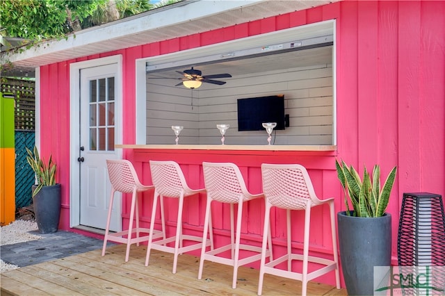 deck featuring ceiling fan and an outdoor bar