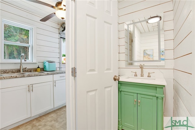 bathroom featuring vanity, wood walls, and ceiling fan