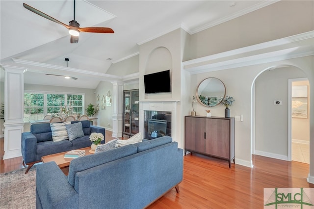 living room featuring light hardwood / wood-style flooring, lofted ceiling, ceiling fan, and crown molding