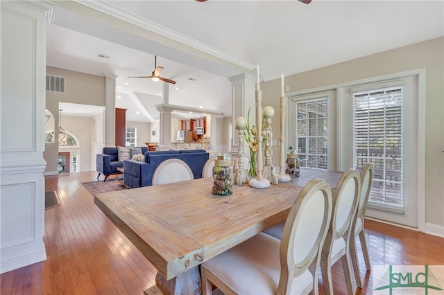 dining room featuring ceiling fan, light hardwood / wood-style floors, and ornate columns