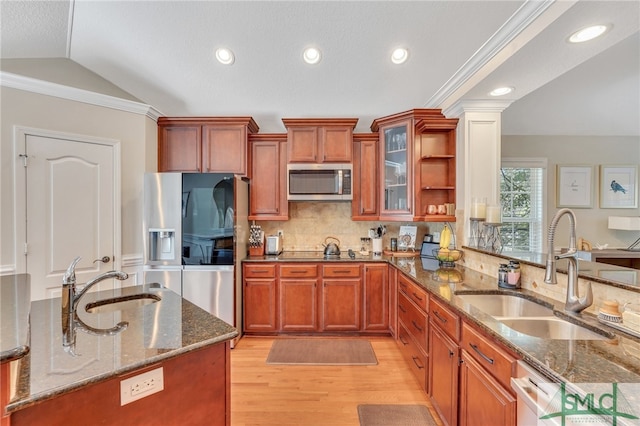 kitchen featuring light hardwood / wood-style floors, sink, vaulted ceiling, appliances with stainless steel finishes, and stone countertops