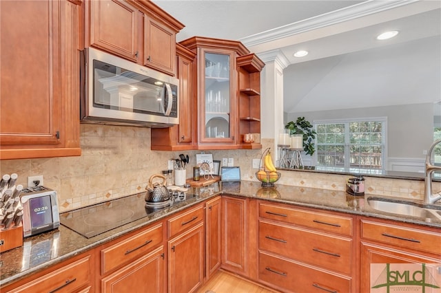 kitchen featuring dark stone counters, ornamental molding, and decorative backsplash