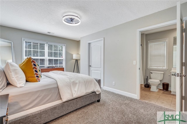 bedroom featuring light colored carpet and a textured ceiling