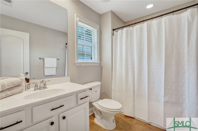 bathroom featuring tile patterned flooring, curtained shower, vanity, and toilet