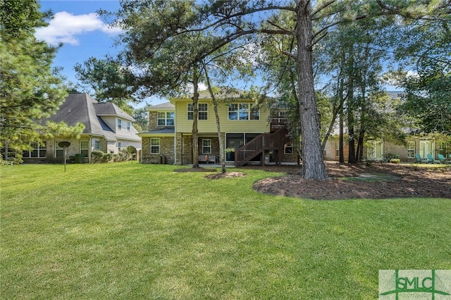 rear view of property featuring a lawn