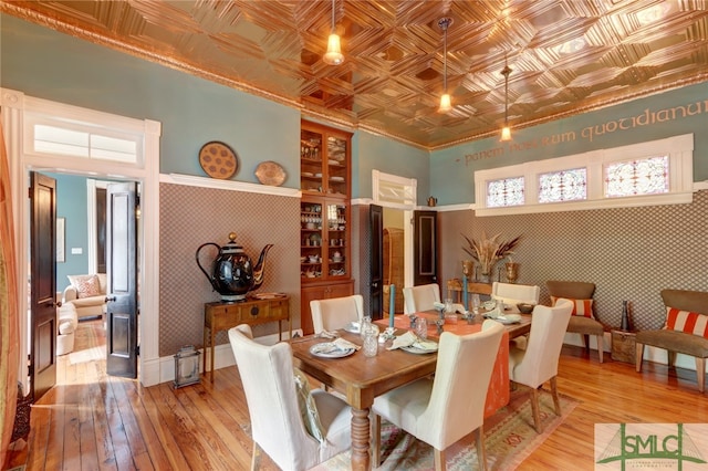 dining space featuring light wood-type flooring, ornamental molding, and built in features