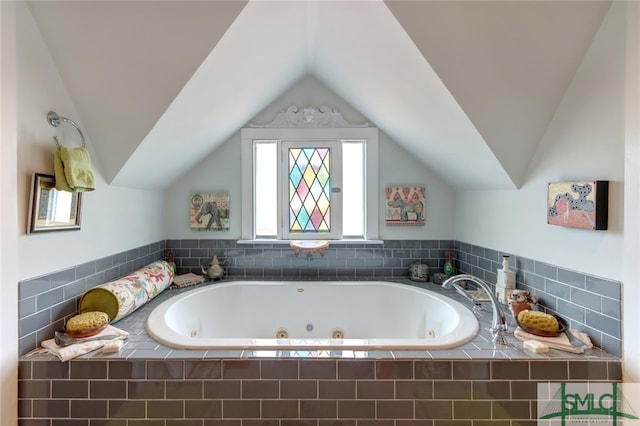 bathroom with a relaxing tiled tub and lofted ceiling