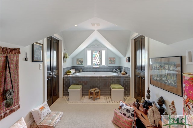 bathroom featuring lofted ceiling and tiled tub