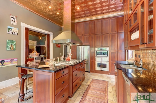 kitchen with island range hood, stainless steel appliances, dark stone counters, and a center island