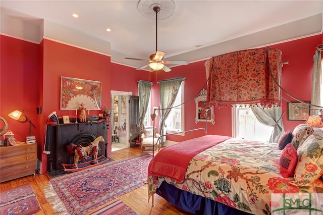 bedroom with light hardwood / wood-style floors, multiple windows, and ceiling fan