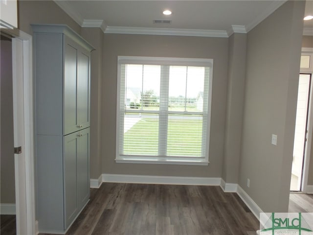 unfurnished dining area featuring ornamental molding, plenty of natural light, and dark hardwood / wood-style flooring