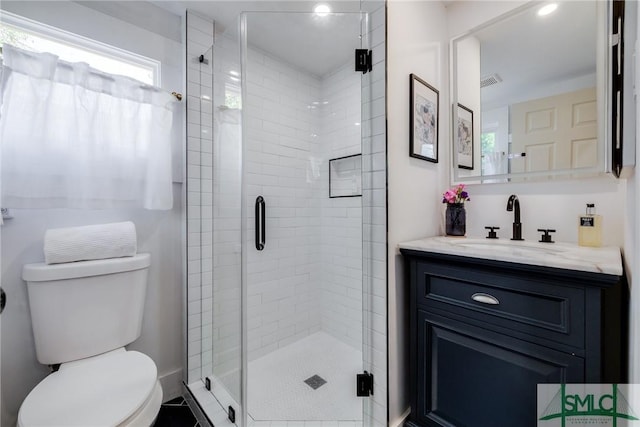 bathroom featuring visible vents, a stall shower, vanity, and toilet