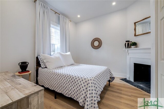 bedroom featuring a fireplace and hardwood / wood-style floors