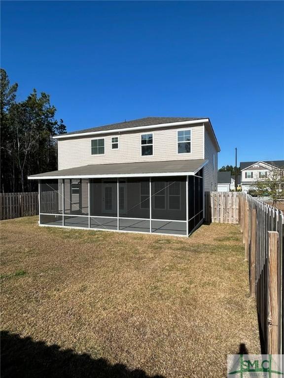 back of house featuring a lawn and a sunroom