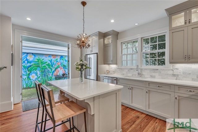 kitchen featuring light hardwood / wood-style floors, decorative light fixtures, sink, and gray cabinetry