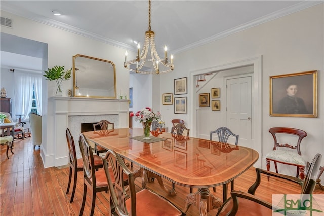 dining area featuring ornamental molding, a chandelier, and light hardwood / wood-style floors