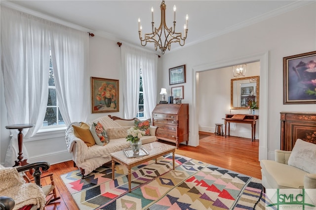 living room featuring ornamental molding, a chandelier, and light wood-type flooring