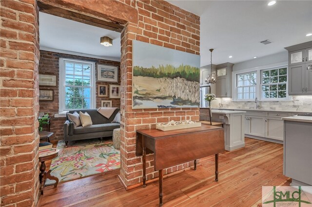 kitchen featuring gray cabinetry, a wealth of natural light, hanging light fixtures, and light hardwood / wood-style floors