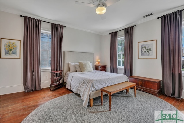 bedroom with ornamental molding, ceiling fan, and wood-type flooring