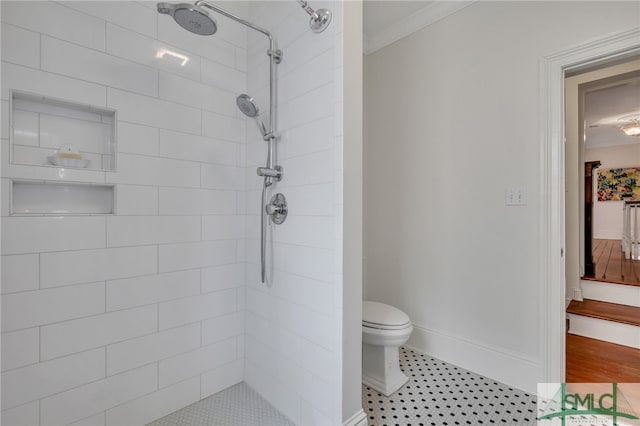 bathroom with hardwood / wood-style floors, a tile shower, crown molding, and toilet