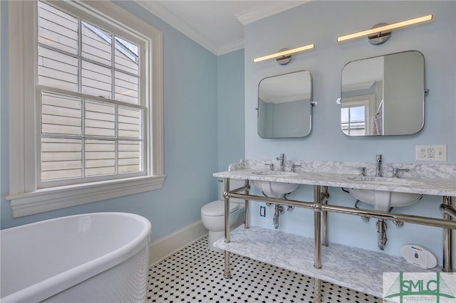 bathroom featuring ornamental molding, vanity, a washtub, and toilet