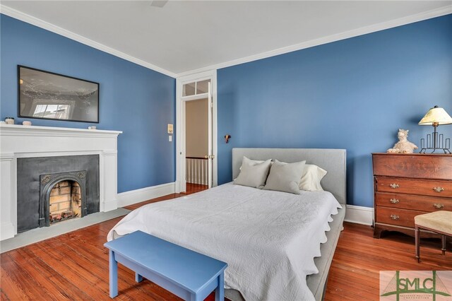 bedroom featuring wood-type flooring and crown molding