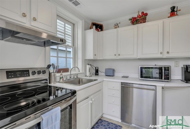 kitchen featuring crown molding, range hood, sink, appliances with stainless steel finishes, and white cabinetry